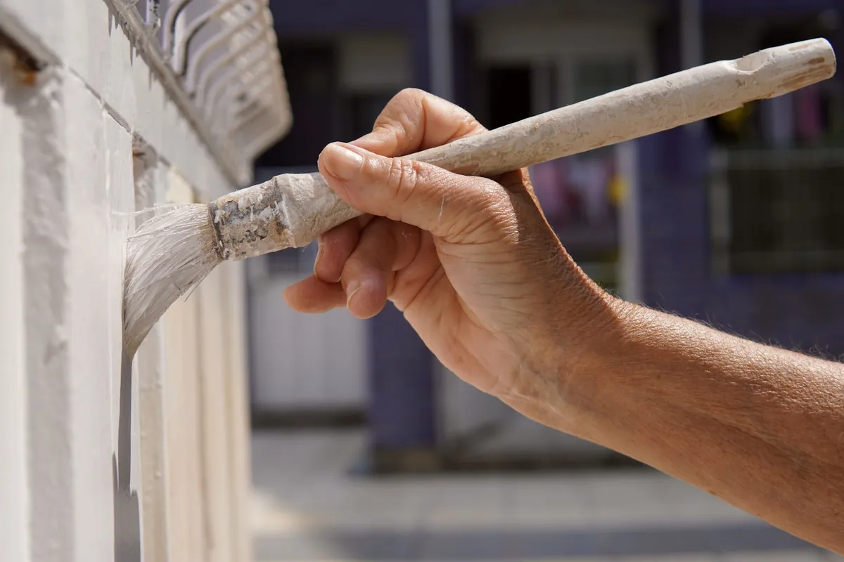 Hand painting white exterior trim with a brush