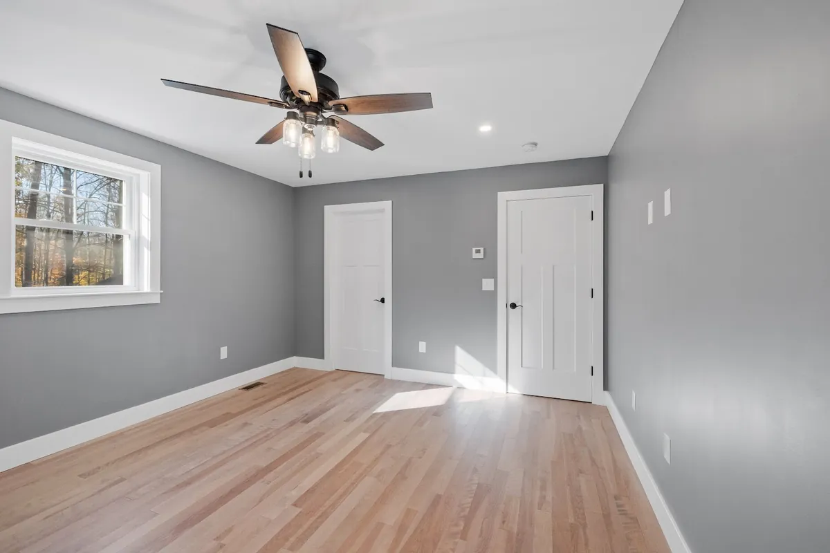Empty bedroom with gray walls, white trim and white doors