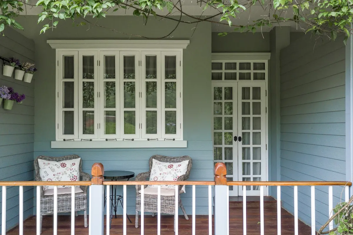 Front porch with light blue siding, white trim and white railings