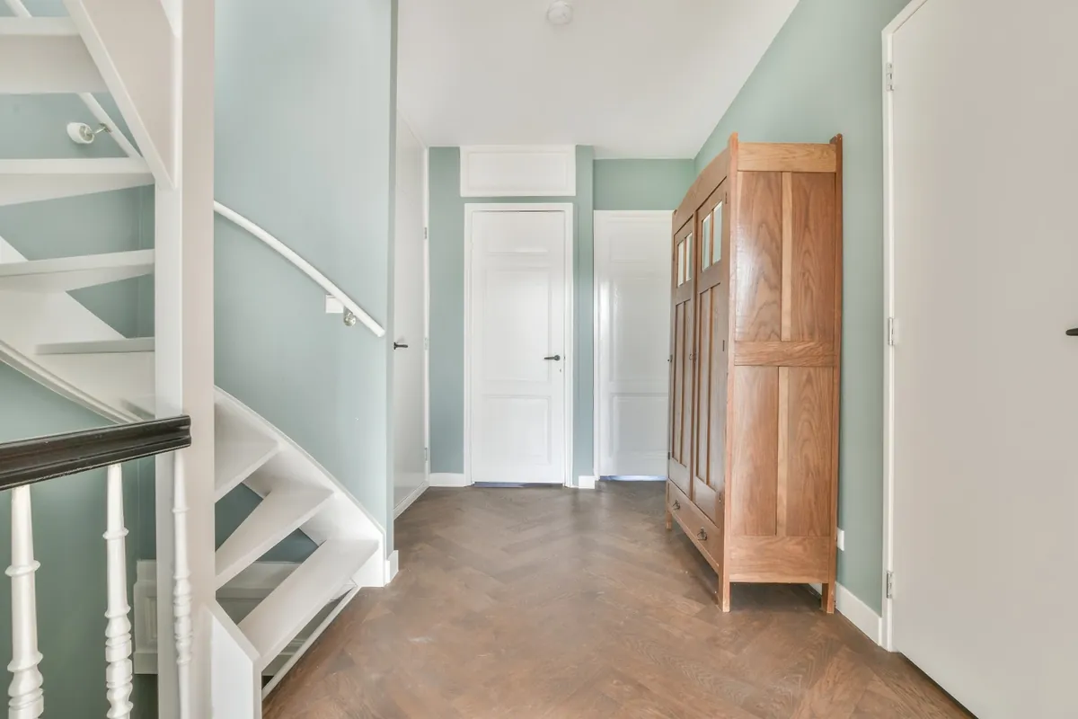 Hallway with soft green walls and white doors