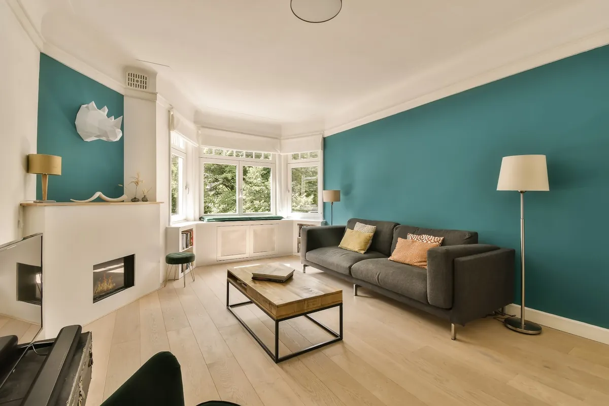 Living room with teal walls and white trim