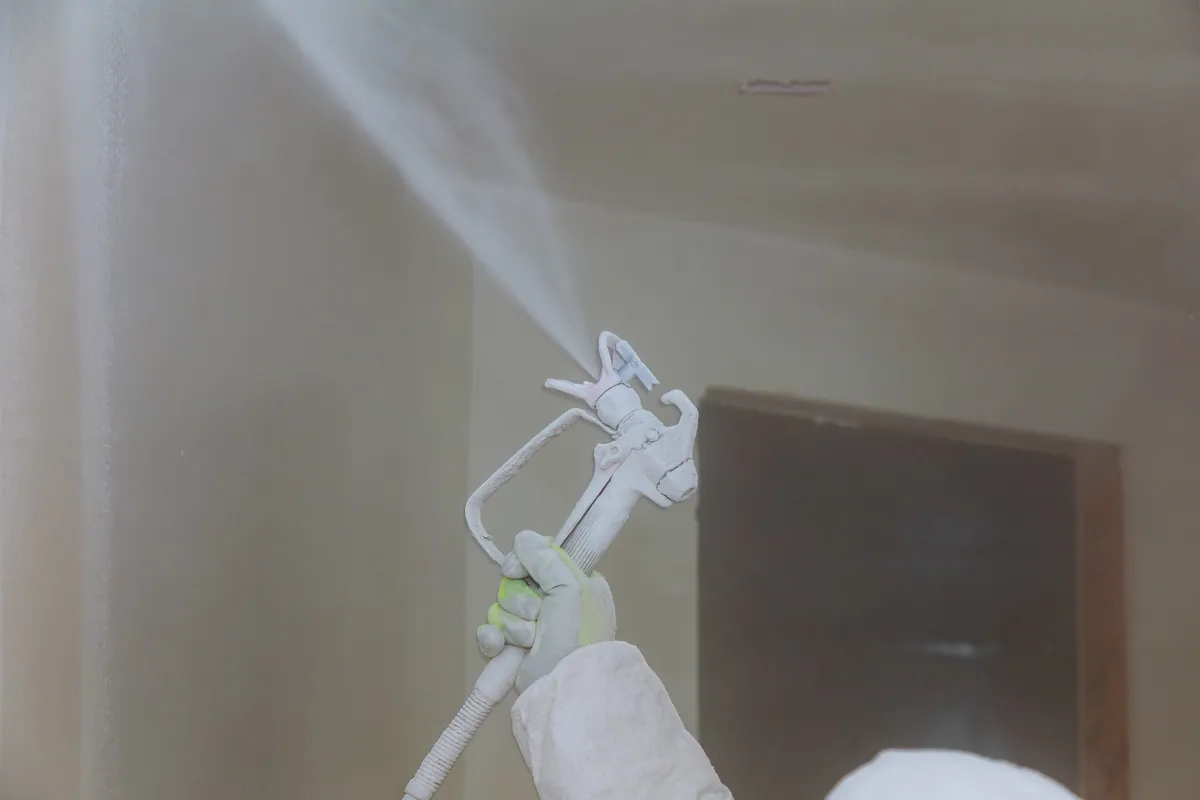 Airless sprayer coating an interior wall white
